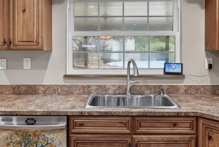 Window in kitchen looking out to the porch and pool area.