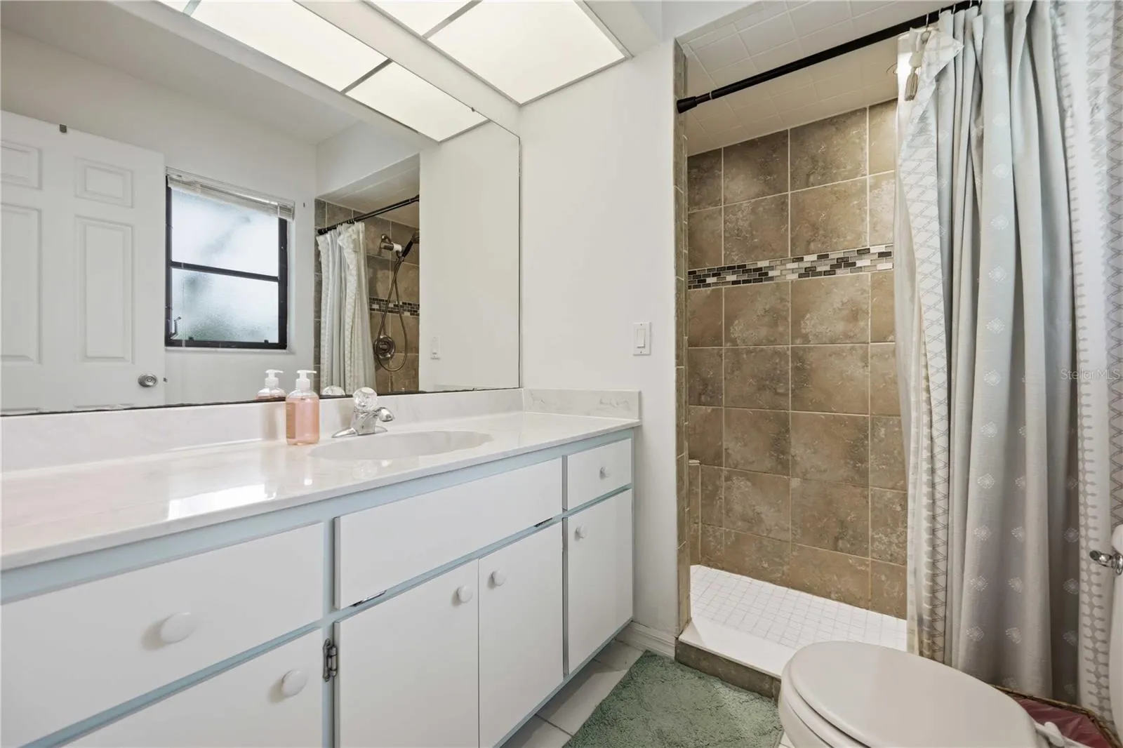 Large primary en suite bathroom with updated finishes