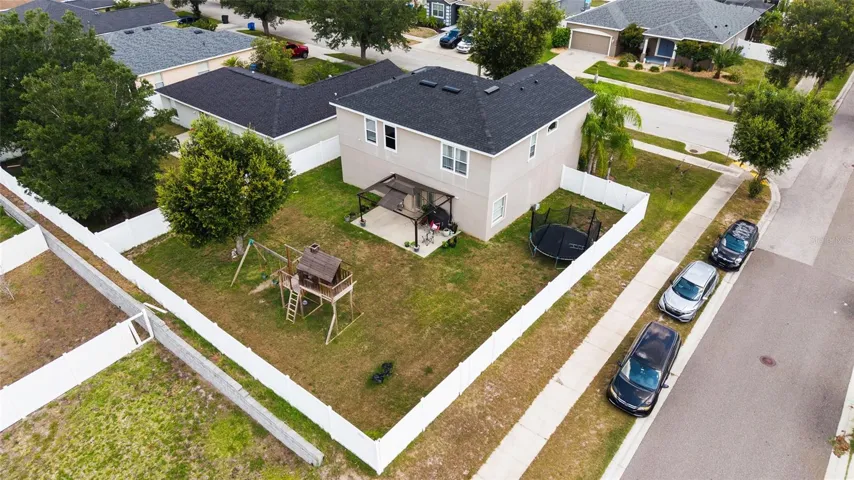 Aerial shot Expansive fenced backyard with plenty of room for entertaining, pets, outdoor activities, or a future pool.