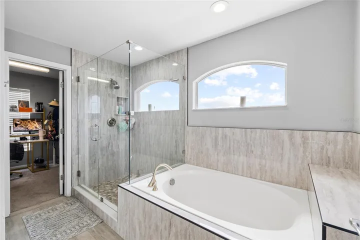 Updated primary bathroom featuring dual vanities, modern finishes, and a spacious layout.