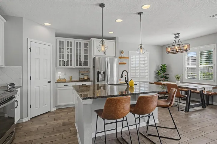 Pendant lighting over the island and accented with glass front cabinets