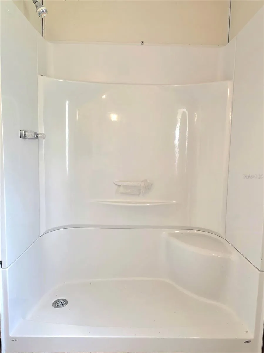 The in-suite bathroom features an updated vanity and shower surround.