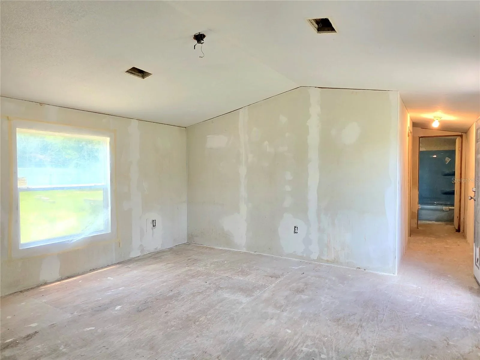 Living room and hallway leading to bedrooms three and four, as well as the main bathroom.
