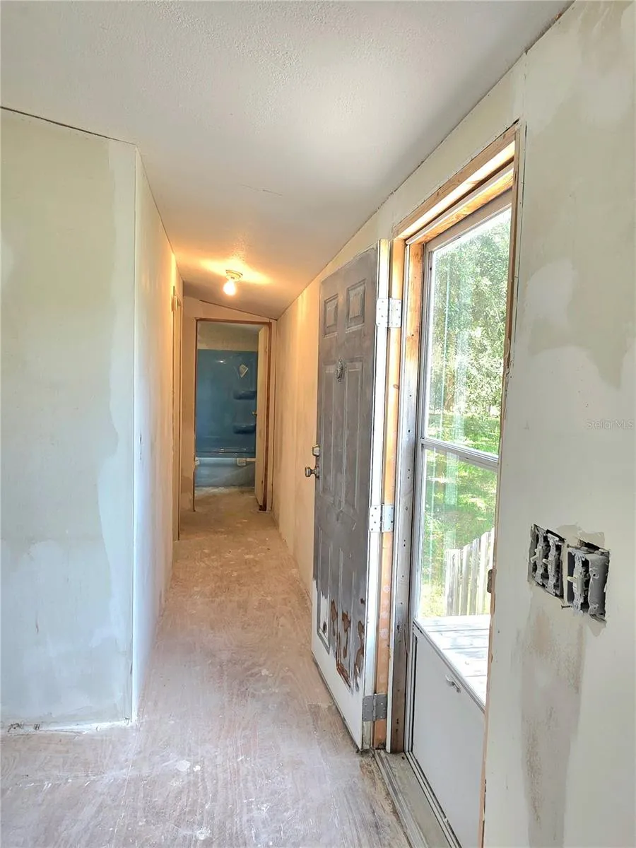 A hallway leads to bedrooms three and four, as well as the main bathroom, and features a door that opens to the front yard.