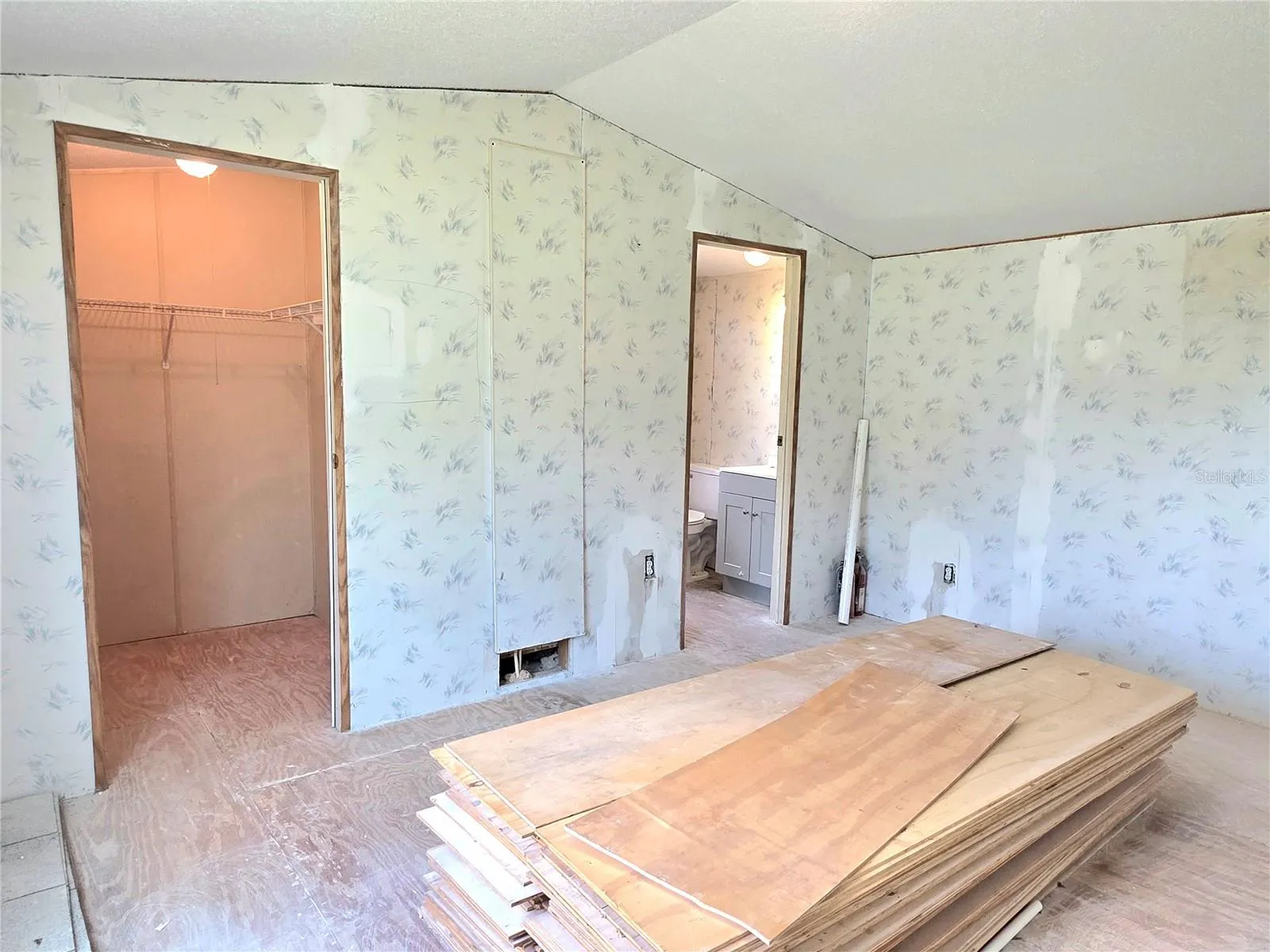 Primary bedroom featuring a walk-in closet and an en-suite bathroom.