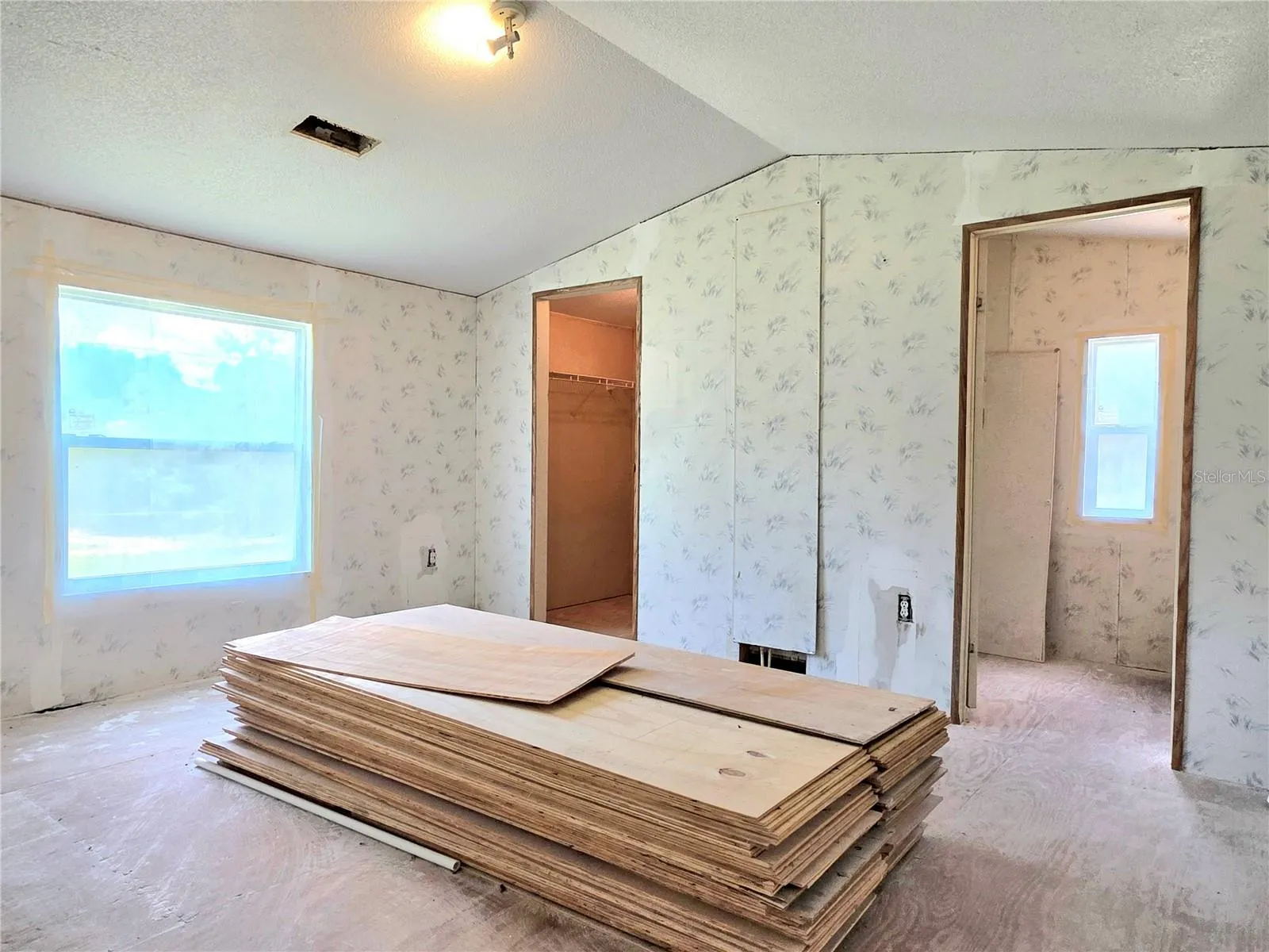 Primary bedroom featuring a walk-in closet and an en-suite bathroom.