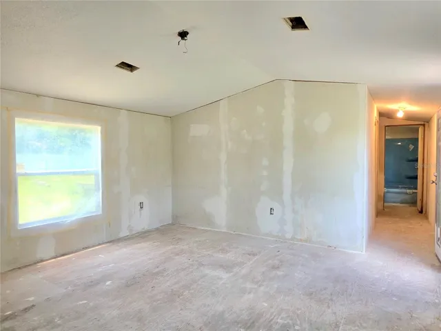 Living room and hallway leading to bedrooms three and four, as well as the main bathroom.