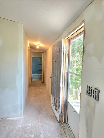 A hallway leads to bedrooms three and four, as well as the main bathroom, and features a door that opens to the front yard.