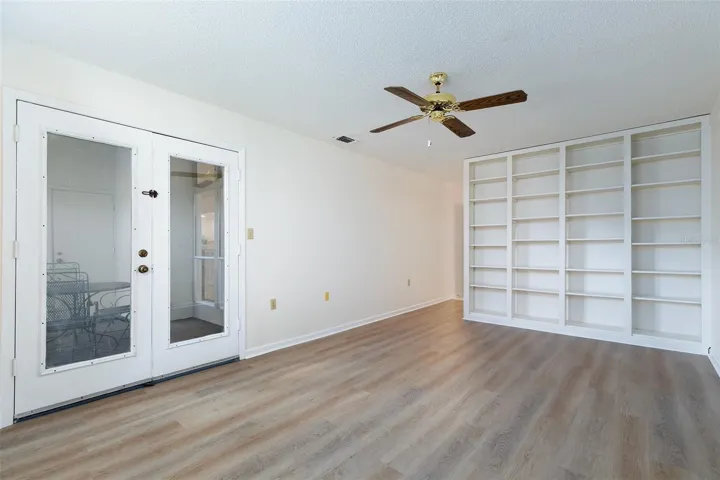 Primary Bedroom offers French Doors to patio & bookshelves.