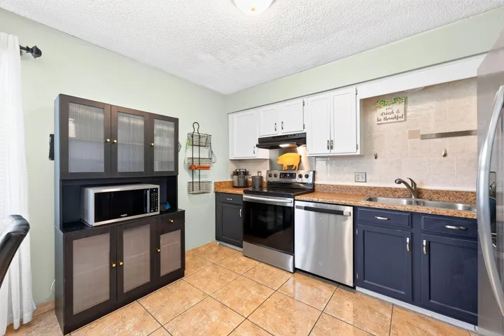 The Kitchen features stainless steel appliances, including a BRAND-NEW DISHWASHER, stone countertops, and a convenient closet pantry.
