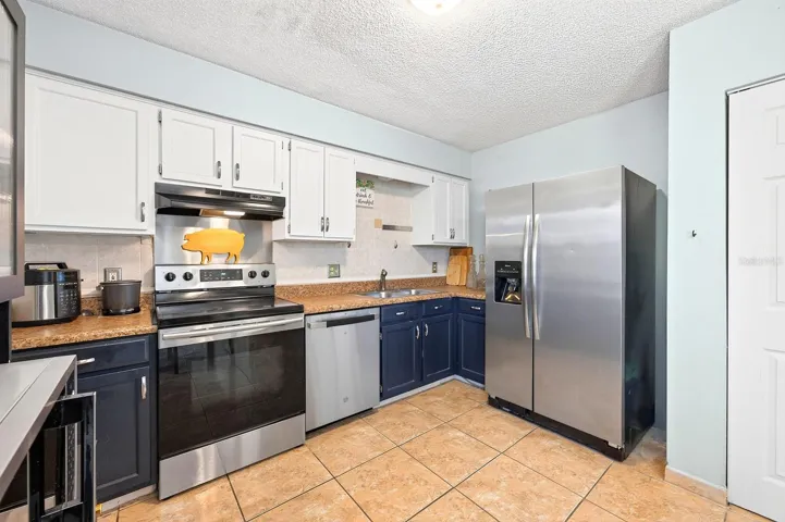 The Kitchen features stainless steel appliances, including a BRAND-NEW DISHWASHER, stone countertops, and a convenient closet pantry.