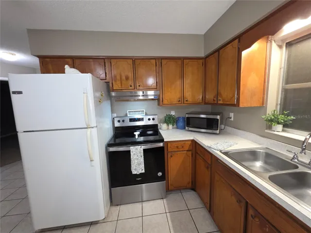 Another view of kitchen showing the stainless steel stove