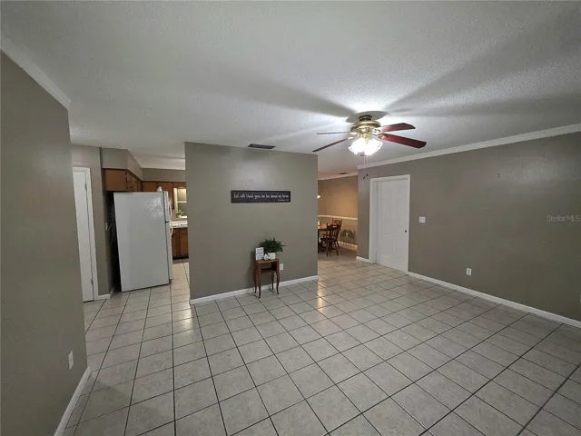 Large living room with tile flooring shown from front door