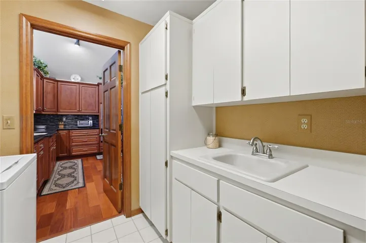 Laundry Main Floor off Kitchen and Garage with Sink Area and Cabinets for Storage