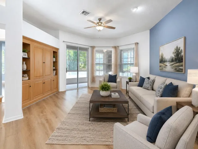Virtually Staged-Living Room features built in entertainmen center and sliders to back lanai while overlooking the dining and kitchen.