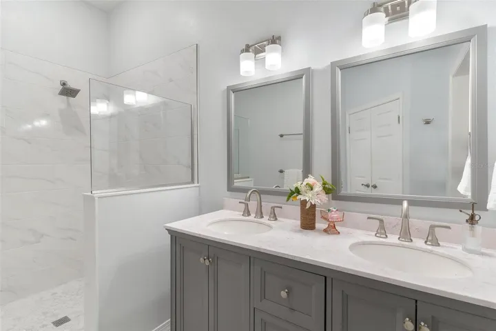 Primary Bathroom #1 features dual vanity sinks and walk in tiled shower