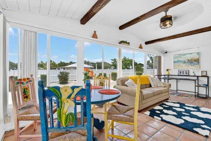 Bright front lanai featuring gorgeous tile and wood beams for decor