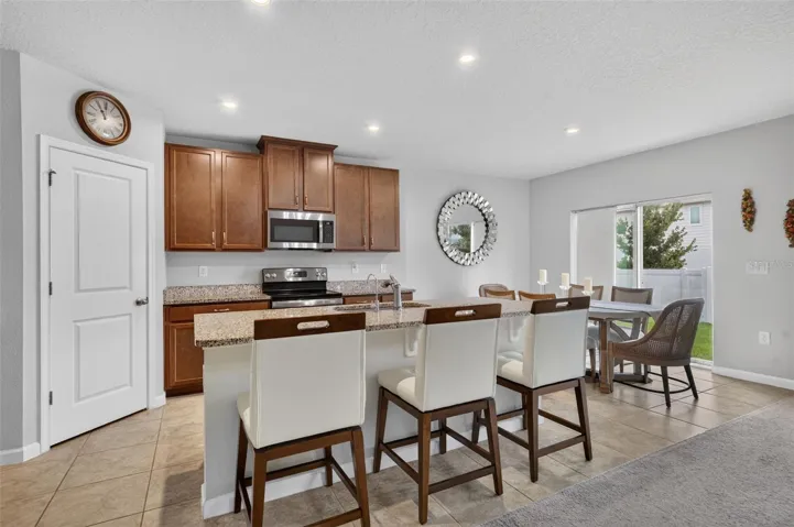 Beautiful wood cabinetry featuring a spacious kitchen island and dedicated dining area and walk-in pantry closet.