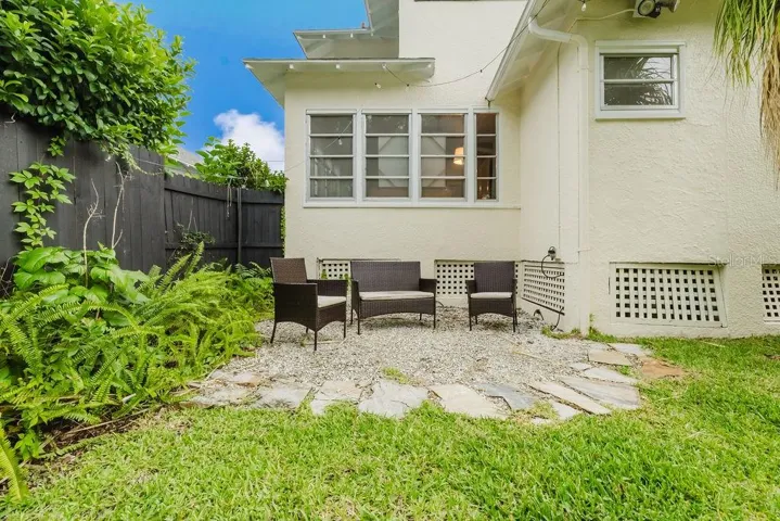 Shell seating area in rear of home in fully fenced, private back yard.