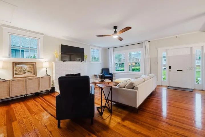 Living room with large brick fireplace and tons of natural light.