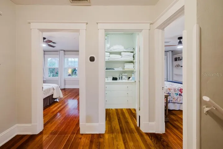 Upstairs linen closet with original built-in shelving and storage.