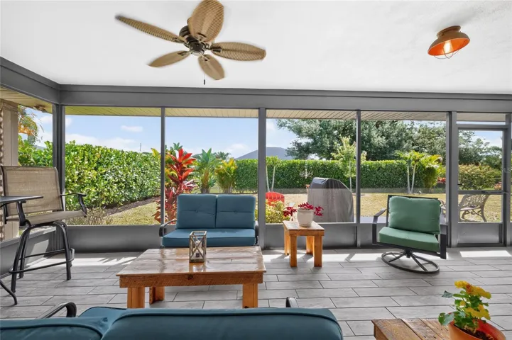 The spacious lanai is screened, has 2 ceiling fans and plank tiled flooring.