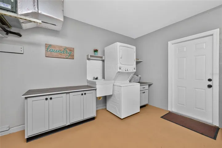 The laundry area is located in the garage. It includes a stackable washer &amp; dryer, utility sink and cabinetry for additional storage.