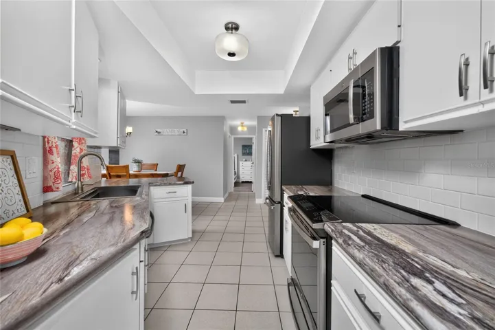 The kitchen has GE stainless steel appliances including a French door refrigerator, smooth top convection range with air fryer, microwave and dishwasher.