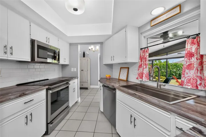 The updated kitchen features Wilsonart textured countertops, subway tile backsplash and has tiled flooring.