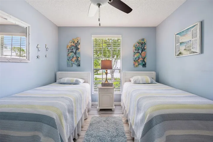 Third bedroom with updated tile flooring, ceiling fan, natural light, and room for guests, family, or flex space.