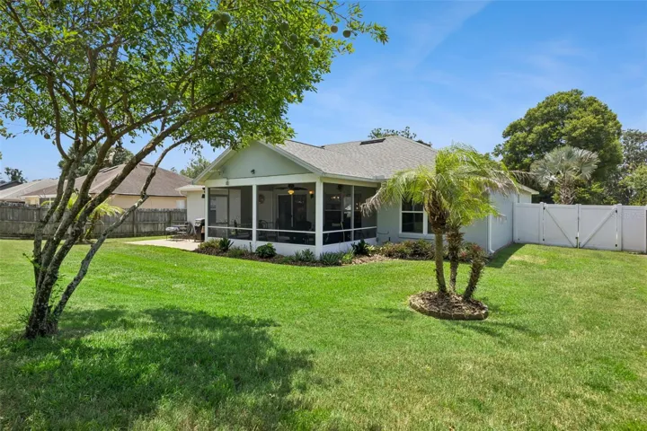 Spacious backyard setting with fencing, lawn area, and mature trees surrounding the property.