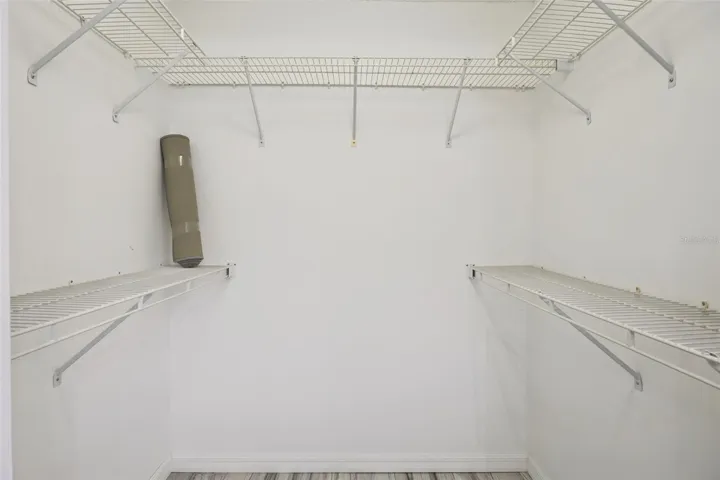 Primary Bedroom walk in closet with shelving and additional storage space.