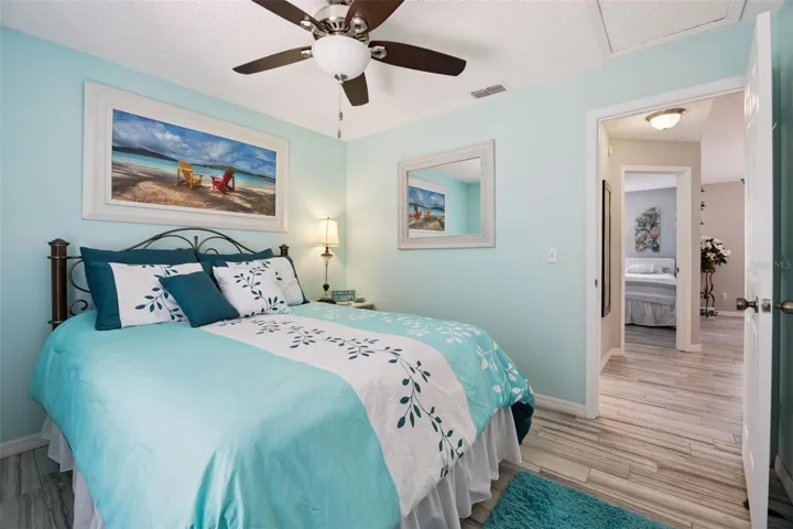 Secondary bedroom with updated tile flooring, ceiling fan, natural light, and flexible use as a guest room, office, or bedroom.
