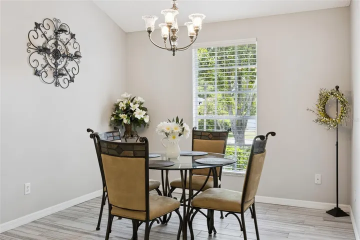 Separate dining room with vaulted ceiling, updated tile flooring, natural light, and a flexible layout for dining, and entertaining.