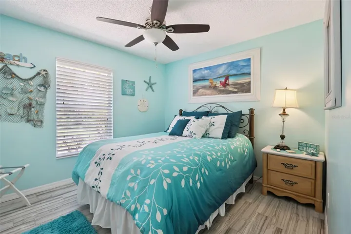 Bright secondary bedroom with updated flooring, ceiling fan, and a comfortable layout for family, guests, or work from home space.