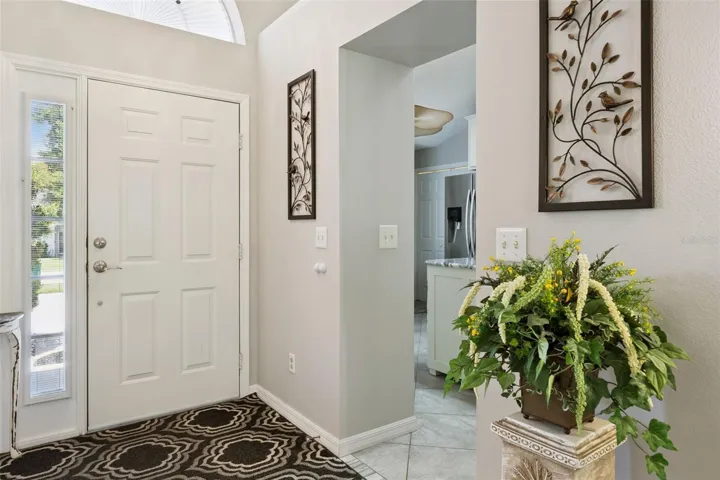 Bright foyer with tile flooring and direct access toward the updated kitchen and main living spaces.