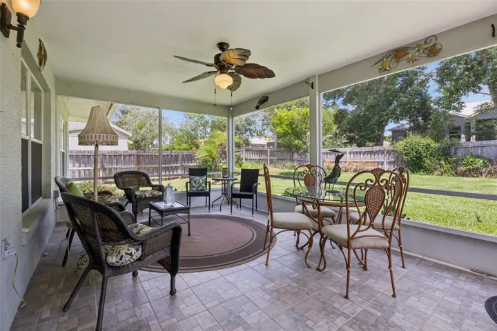 Spacious screened patio overlooking the fenced backyard, creating an ideal outdoor living area for relaxing or entertaining.