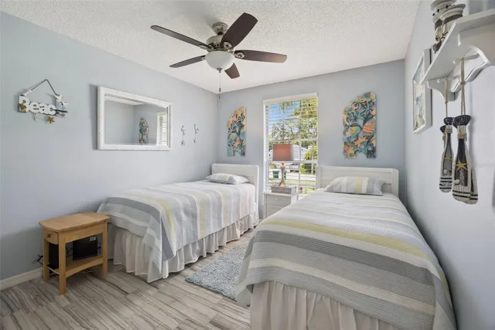 Third bedroom with updated tile flooring, ceiling fan, natural light, and room for guests, family, or flex space.