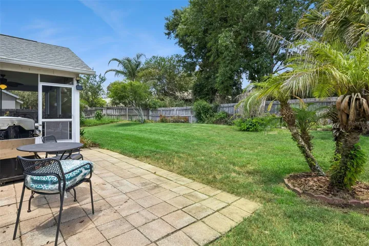 Private fenced backyard with mature landscaping, usable green space, and room for pets, play, gardening, or outdoor gatherings.
