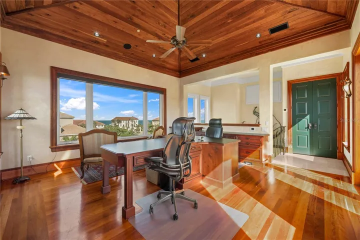 A private executive office with rich wood detailing, soaring ceilings, and views that make working from home feel a little unfair.