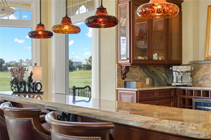 Morning espresso, evening wine, and front-row views of the fairway—all from a gathering space where conversation naturally settles around the island beneath handcrafted Murano leopard glass pendants.