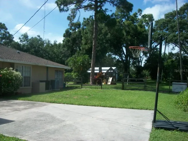 Standing closer in front yard looking into back yard, 2 Car Garage to the laft