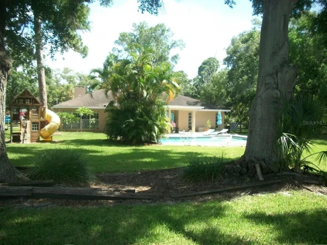Standing in back yard looking at home and pool area