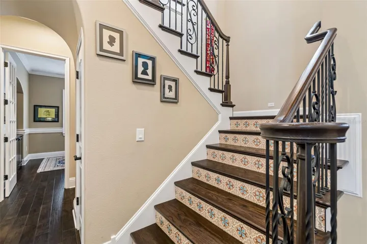 Stair case with custom Spanish riser tiles. Office on the left.