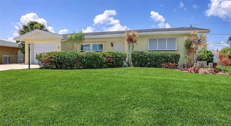Bahama shutters and a lush green front yard welcome you.