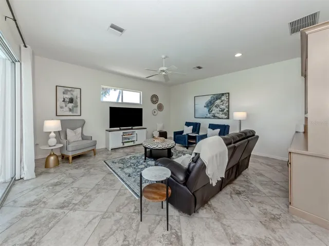 The large family room includes sliding glass door access to the lanai, custom built in cabinetry with lighting and pullouts for extra storage and large transom window