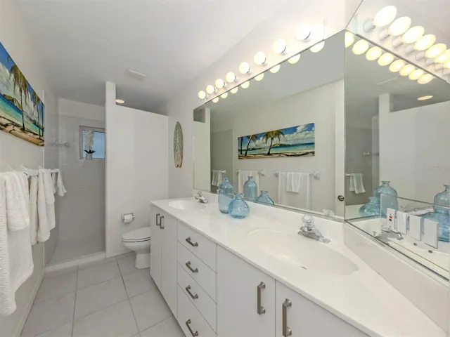 The second full bath is shared by both the second and third bedrooms and includes tall counters, dual sinks, and walk in shower