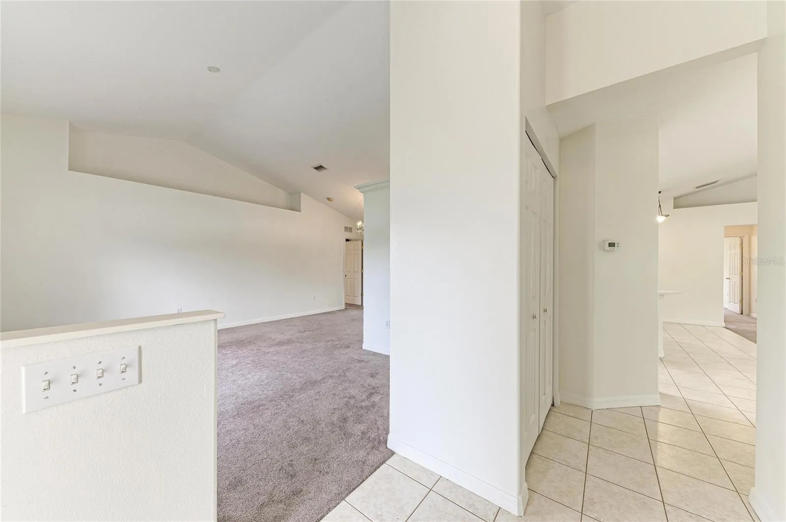 Foyer opens to living room to left and family room to right