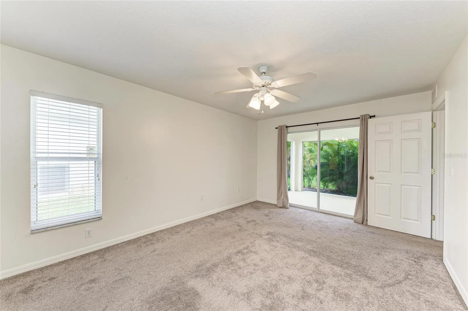 Primary Bedroom with sliding glass doors to screened lanai