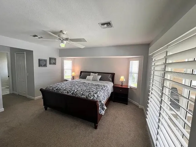 Primary Suite enjoys access to the pool deck along with waterfront views